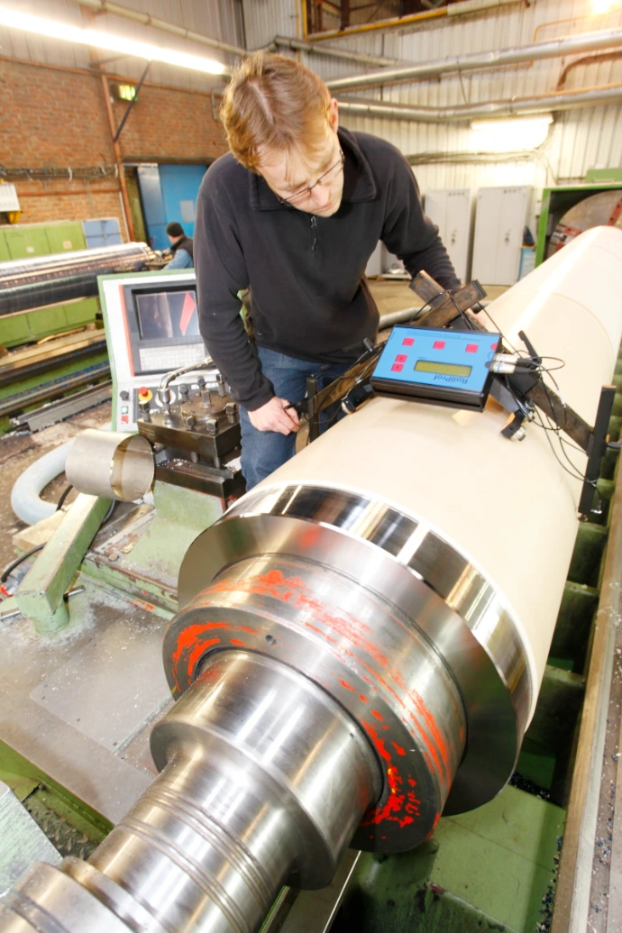 Roval technician controlling density profile during calender roll filling process